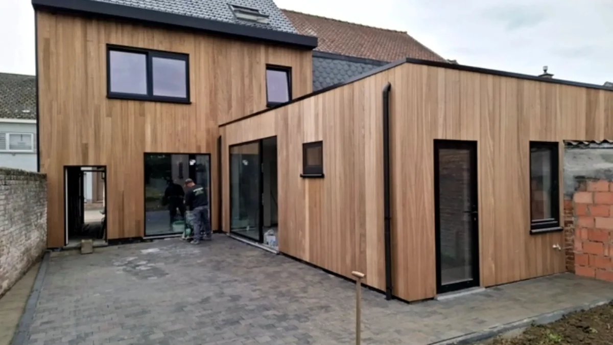 Houten bijgebouw met zwarte ramen en grote glaspartijen