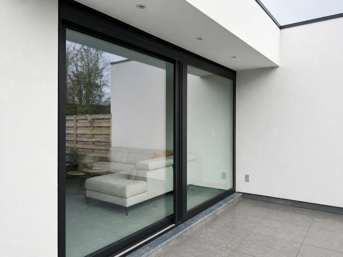 Black aluminum sliding window with large glass areas in a white rear facade