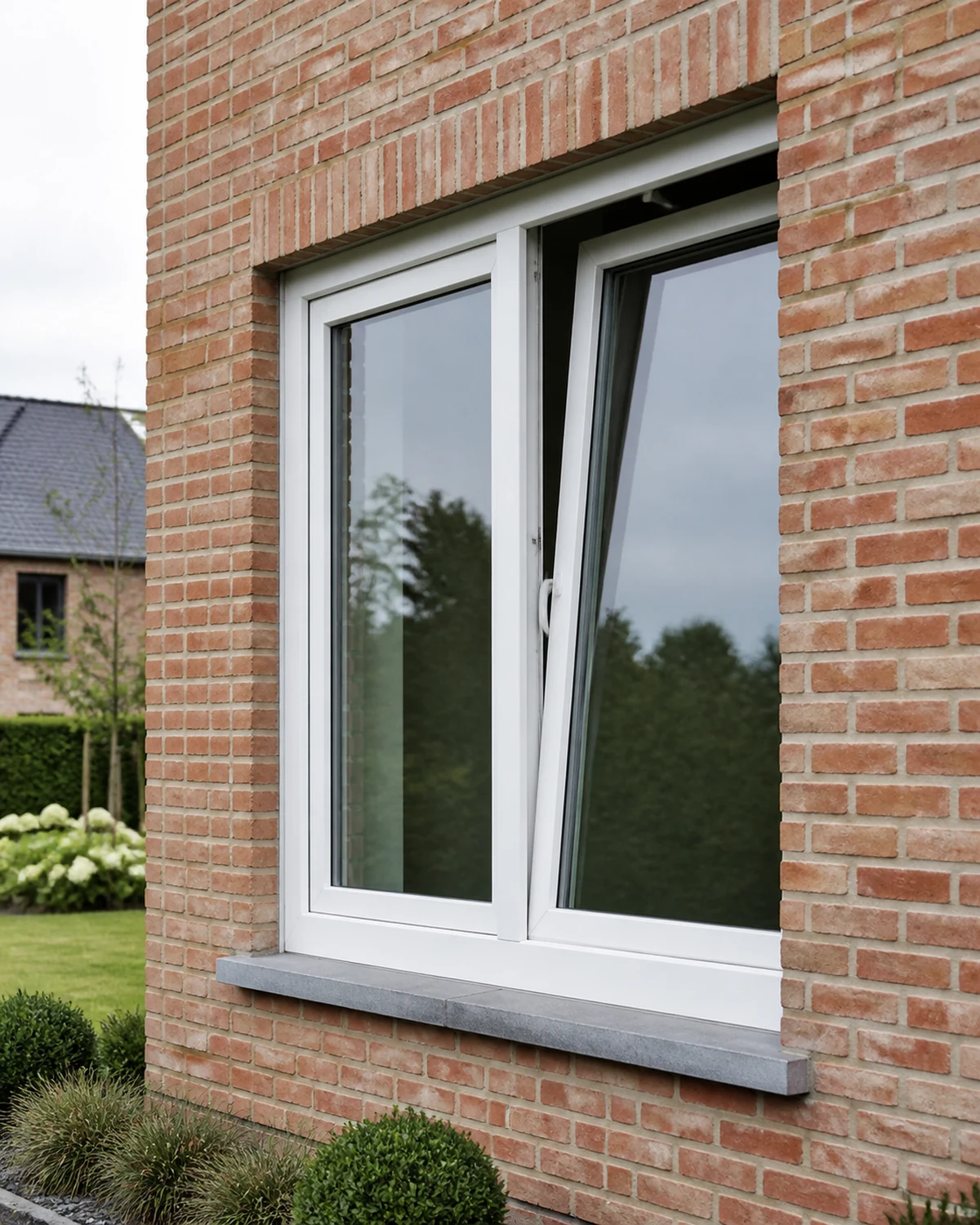 White PVC tilt-and-turn window in a Belgian brick facade